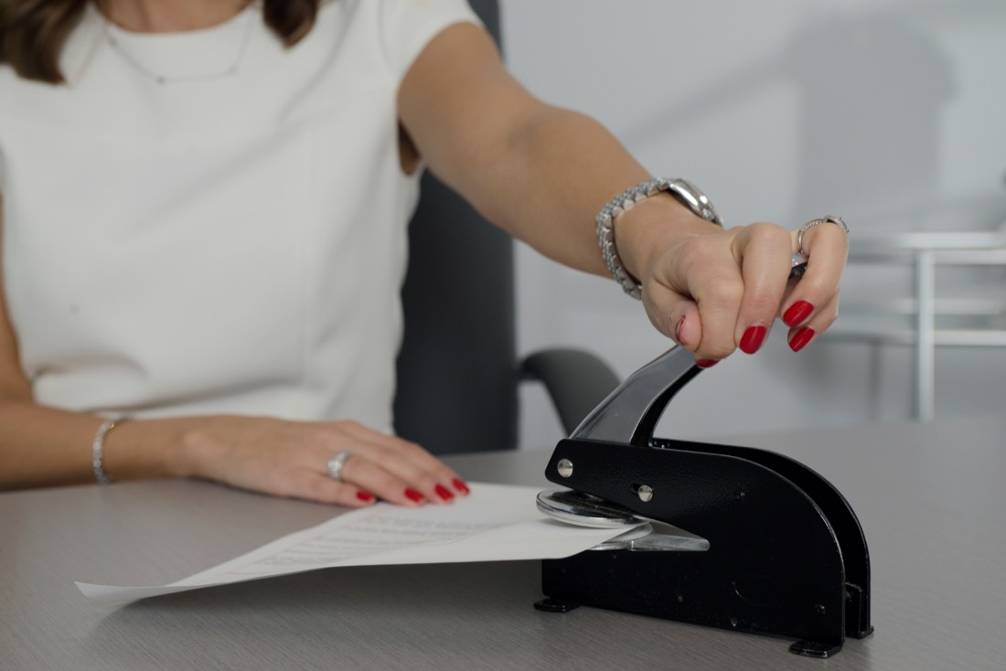 An official embossing a seal onto a document